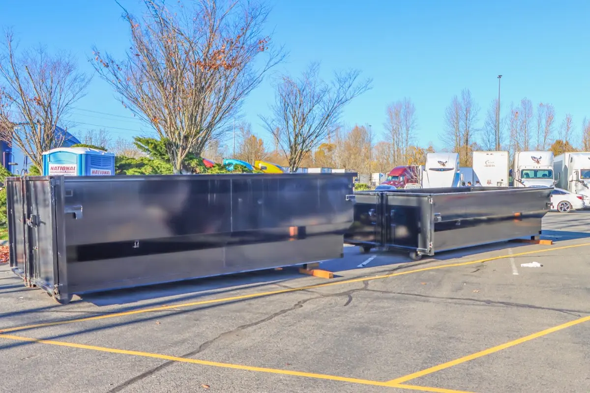 Professional dumpster rental service with roll-off container on residential driveway in Pittsgrove